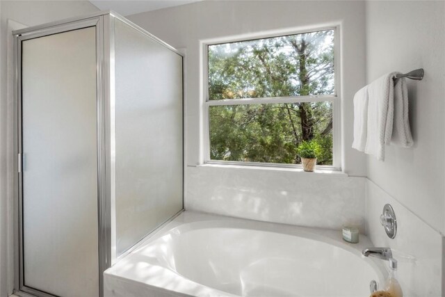 bathroom featuring a bath and a stall shower