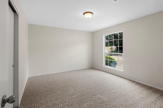 empty room featuring baseboards and carpet floors