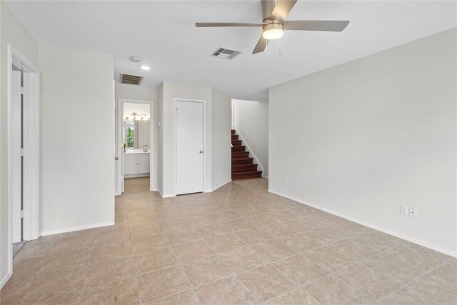 spare room featuring stairway, baseboards, and visible vents