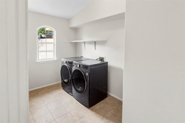 laundry area with laundry area, light tile patterned floors, washing machine and dryer, and baseboards