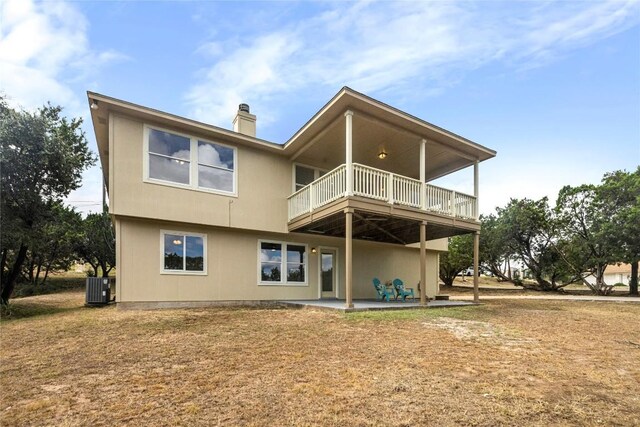 back of property with central AC, a chimney, and a patio area