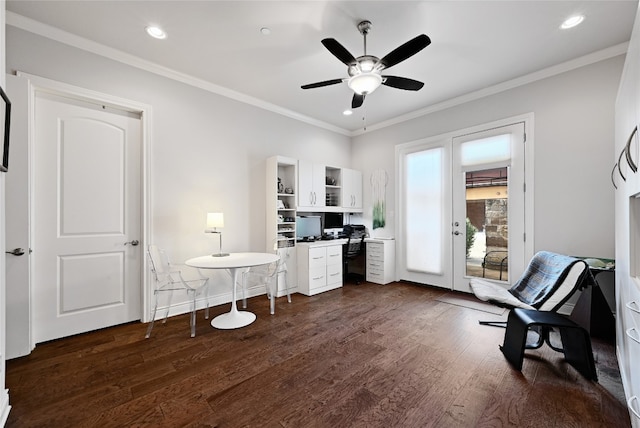 office area featuring dark wood-type flooring, ceiling fan, ornamental molding, and built in desk