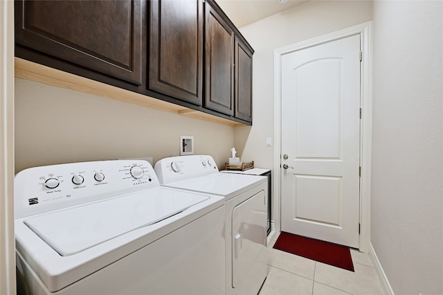 washroom with cabinets, washer and clothes dryer, and light tile patterned floors