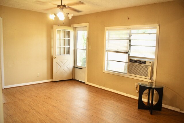 doorway to outside featuring cooling unit, ceiling fan, hardwood / wood-style flooring, and plenty of natural light