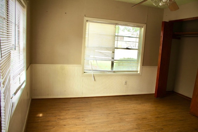 unfurnished bedroom featuring hardwood / wood-style floors, ceiling fan, and a closet