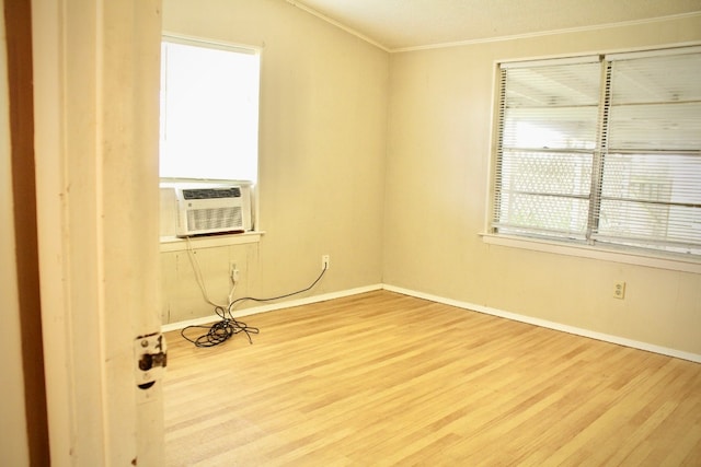 empty room featuring cooling unit, hardwood / wood-style flooring, and crown molding