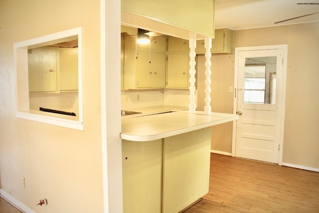 kitchen featuring kitchen peninsula, cream cabinetry, and light hardwood / wood-style floors