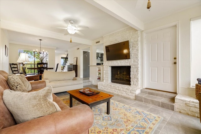 living room with light tile patterned floors, ornamental molding, a brick fireplace, ceiling fan with notable chandelier, and beamed ceiling