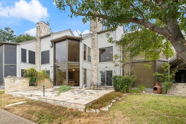 rear view of house with a patio area and a lawn