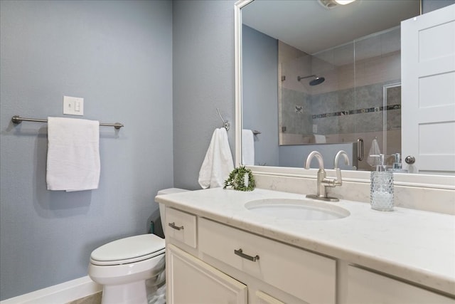 bathroom featuring a shower with door, vanity, and toilet