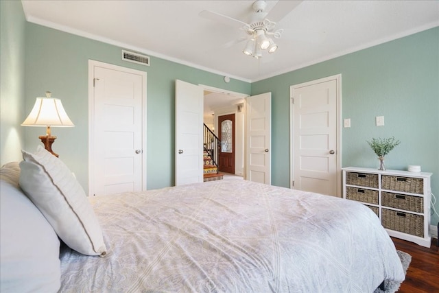 bedroom with dark wood-type flooring, ceiling fan, and ornamental molding