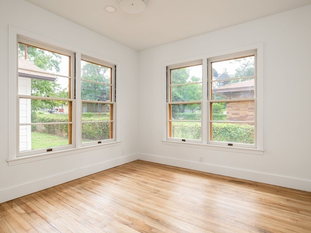 unfurnished room with plenty of natural light and light hardwood / wood-style flooring