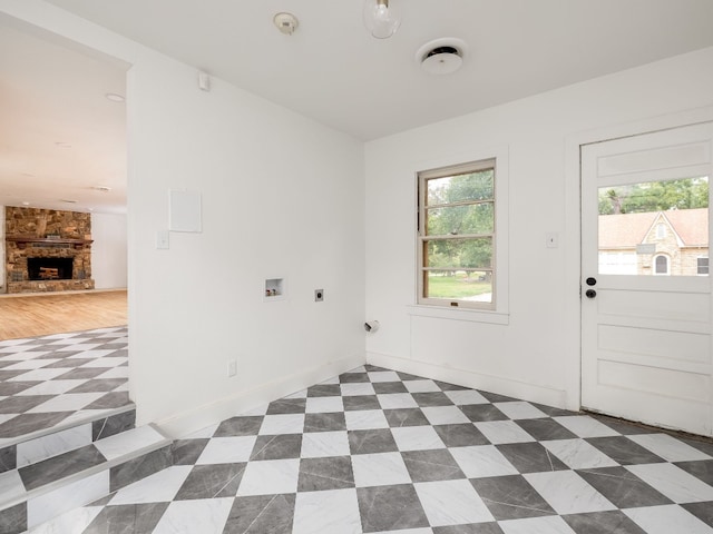 spare room featuring a stone fireplace