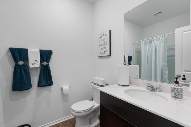 bathroom with vanity, toilet, and hardwood / wood-style flooring