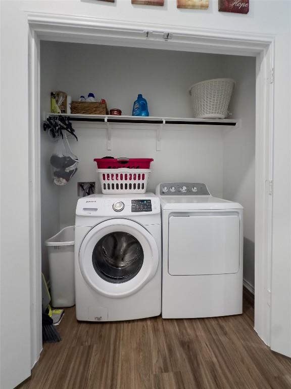 washroom with dark hardwood / wood-style floors and washing machine and clothes dryer