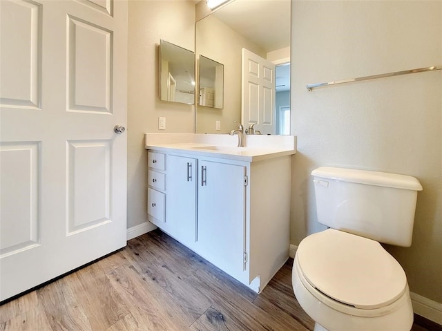 bathroom featuring vanity, toilet, and hardwood / wood-style floors