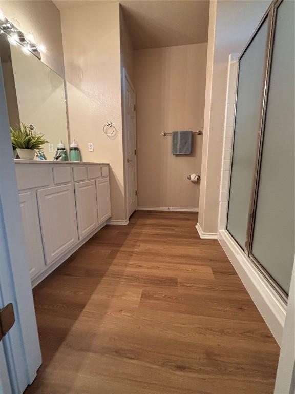 bathroom featuring vanity, hardwood / wood-style flooring, and a shower with door