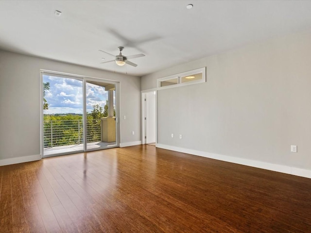 empty room featuring a ceiling fan, baseboards, and wood finished floors