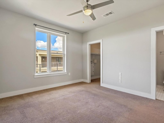 unfurnished bedroom featuring visible vents, carpet flooring, baseboards, and a spacious closet