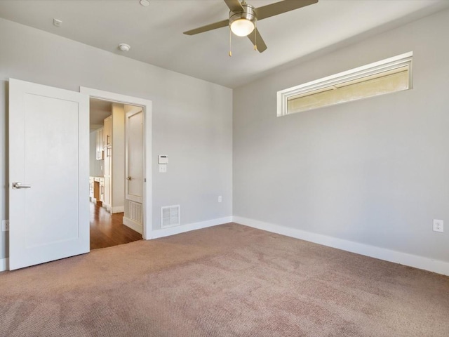 unfurnished bedroom with baseboards, a ceiling fan, carpet flooring, and visible vents