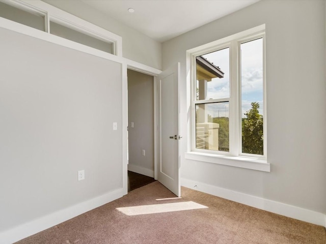 empty room featuring baseboards and carpet flooring