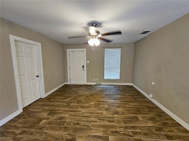 empty room featuring dark wood-type flooring and ceiling fan