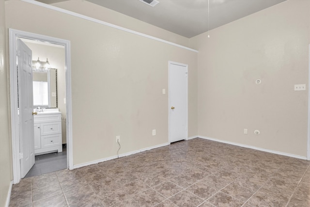 unfurnished bedroom with ensuite bathroom and sink