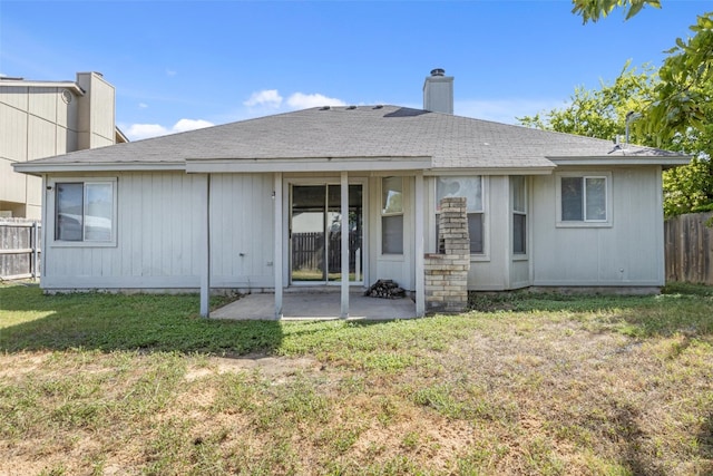 rear view of house featuring a lawn and a patio