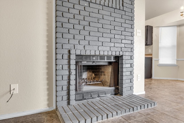 interior details with a brick fireplace and tile patterned flooring