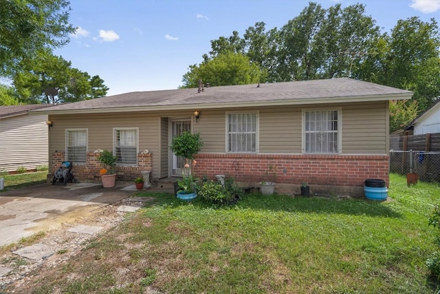 view of front of house featuring a front yard, brick siding, and fence