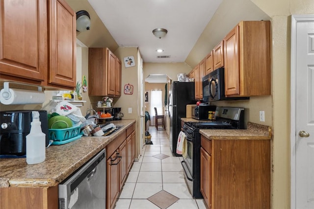 kitchen featuring arched walkways, light tile patterned flooring, a sink, visible vents, and black appliances