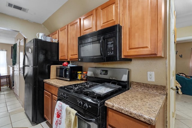 kitchen featuring black appliances, visible vents, arched walkways, and light tile patterned flooring