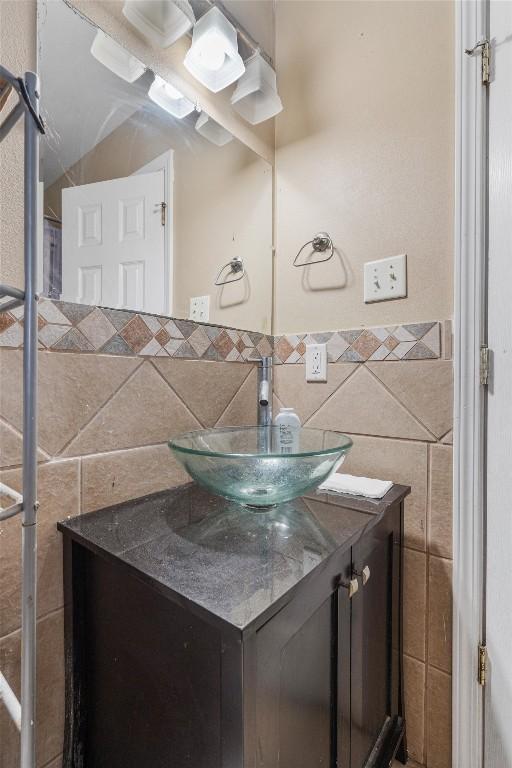 bathroom featuring vanity and tile walls