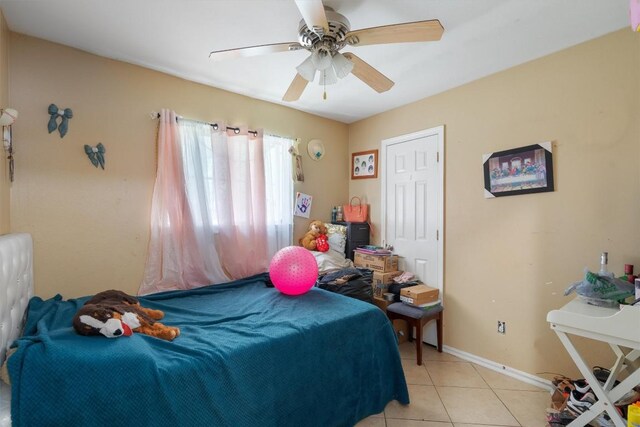 bedroom with a ceiling fan, light tile patterned flooring, and baseboards