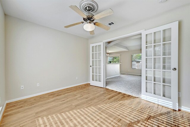 empty room with ceiling fan, french doors, and light hardwood / wood-style flooring