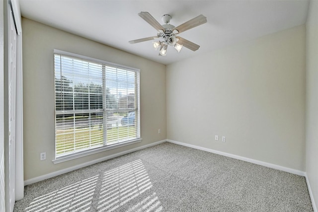 carpeted empty room featuring ceiling fan and a wealth of natural light