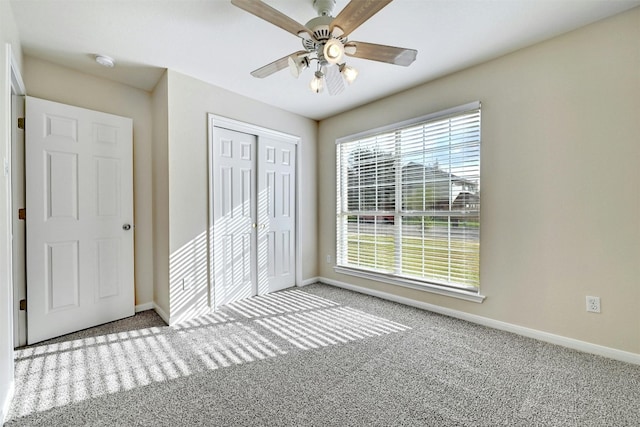 unfurnished bedroom featuring ceiling fan, a closet, and light carpet