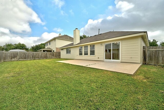 rear view of property featuring a patio area and a yard