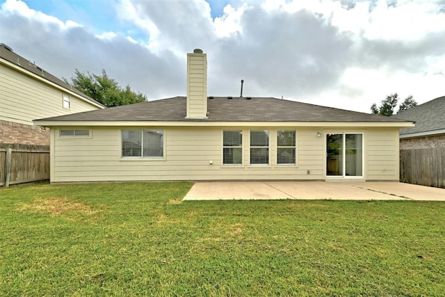 back of house with a yard and a patio