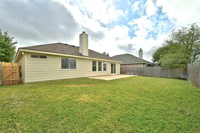 back of house with a patio area and a lawn