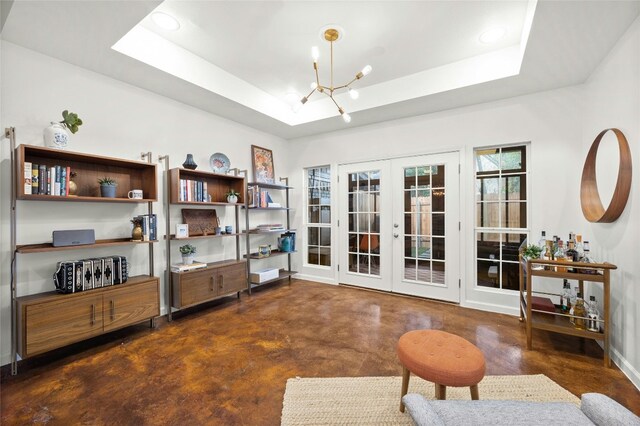 interior space featuring french doors, a notable chandelier, and a tray ceiling