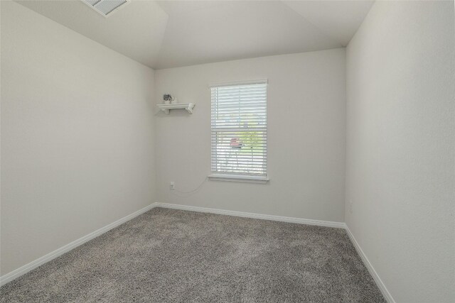 empty room featuring vaulted ceiling, baseboards, visible vents, and carpet floors