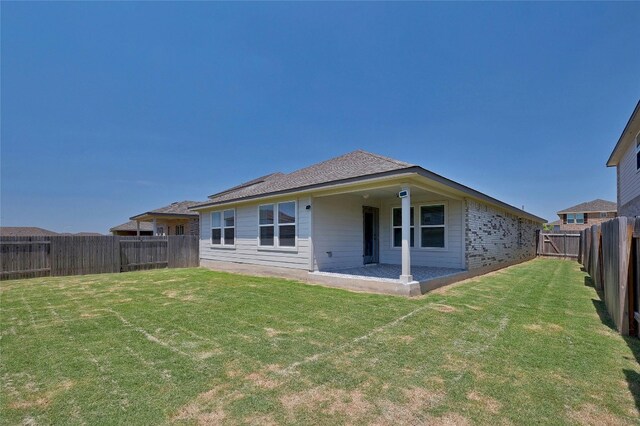 back of property featuring a lawn, a patio, and a fenced backyard