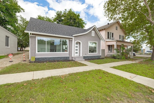 view of front of home featuring covered porch and a front lawn