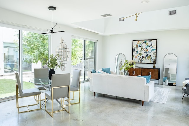 living room with concrete floors, visible vents, and an inviting chandelier