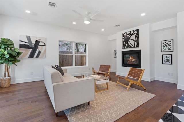 living room with ceiling fan and dark hardwood / wood-style flooring