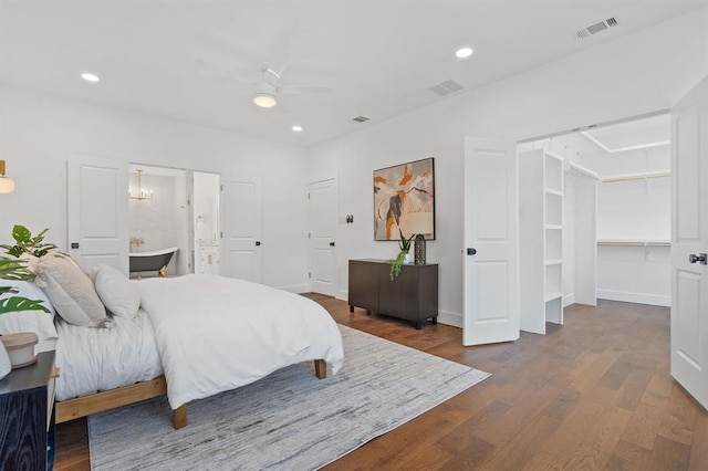 bedroom featuring ceiling fan, ensuite bath, and dark hardwood / wood-style flooring