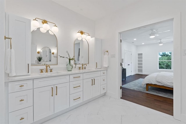 full bathroom featuring double vanity, ceiling fan, baseboards, and a sink
