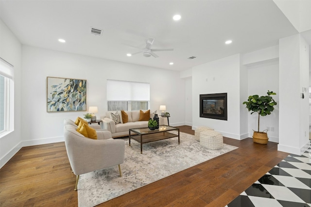 living room with ceiling fan, dark hardwood / wood-style floors, and a wealth of natural light