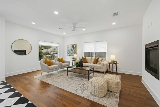 living room with dark hardwood / wood-style flooring and ceiling fan